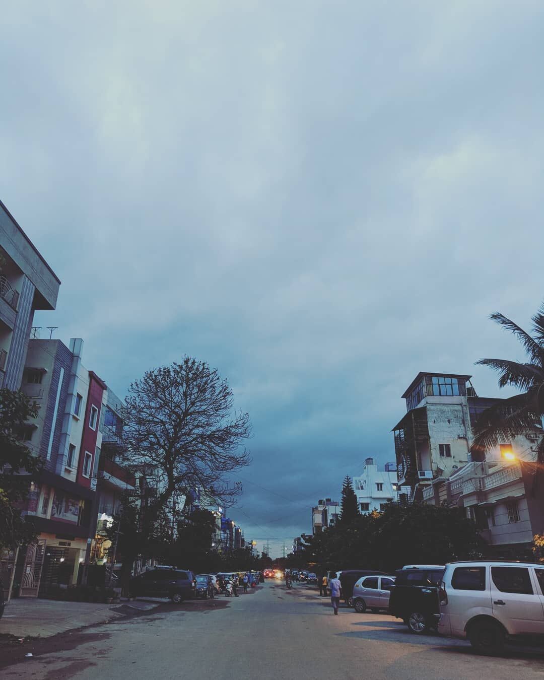 Photo of an empty street with the evening sky looming behind